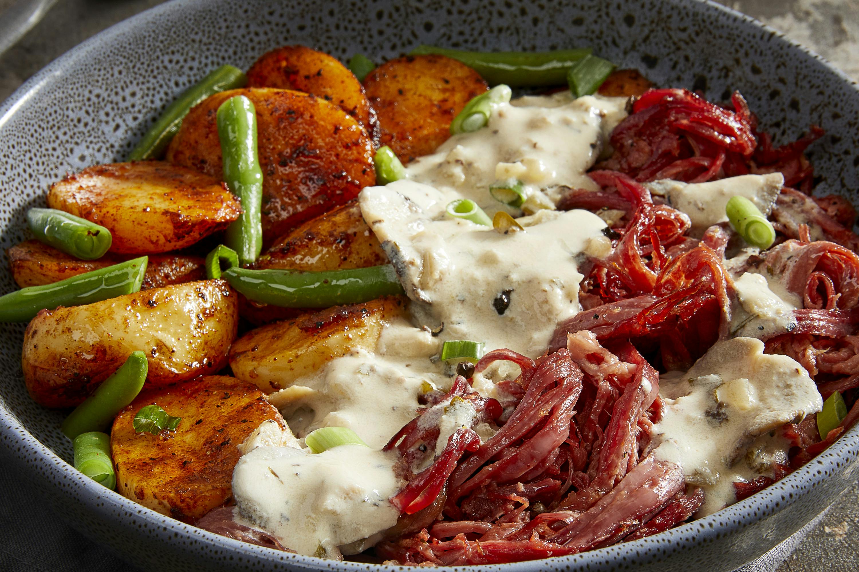 A steamy bowl of potato, greens and beef brisket.